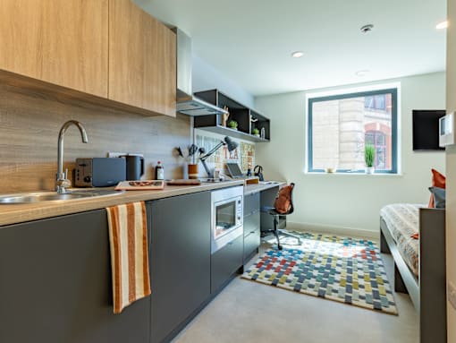 A kitchen with a black counter top and a striped towel hanging on the faucet.