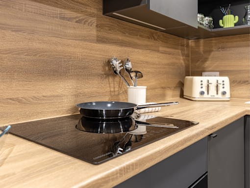 A modern kitchen with a stove top and a toaster on the counter.