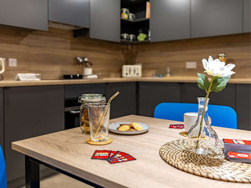 A dining table with a vase of flowers and a plate of food on it.