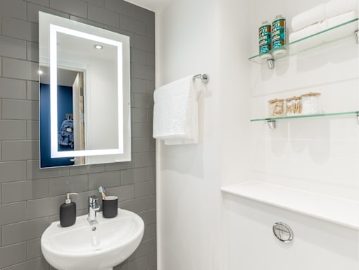 A white sink with a mirror above it in a bathroom.