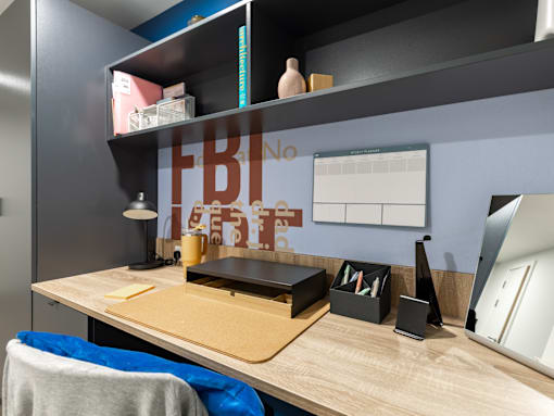 A desk with a laptop, a lamp, and a few other items on it.
