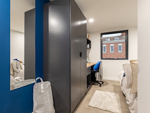 A room with a blue accent wall and a large mirror.
