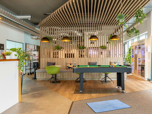 A room with a pool table and a green chair.