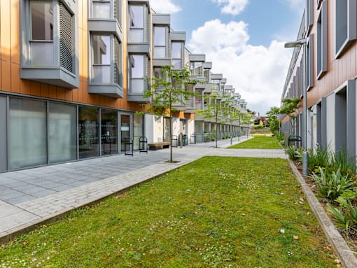 A long row of modern buildings with trees in front of them.