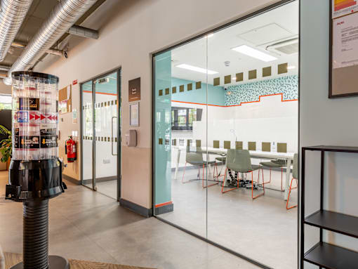 A glass wall separates two rooms in a modern office.