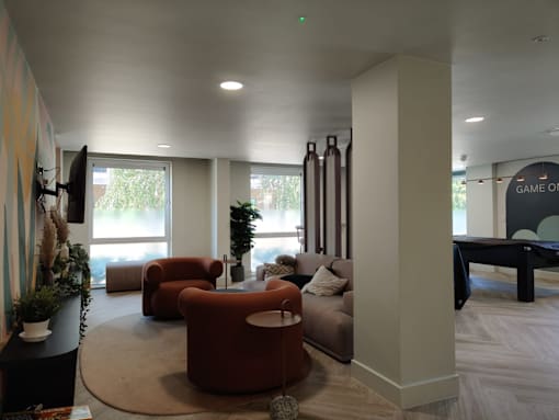 A living room with a couch, chair, and television.