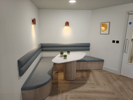 A modern living room with a grey sofa and a white table.