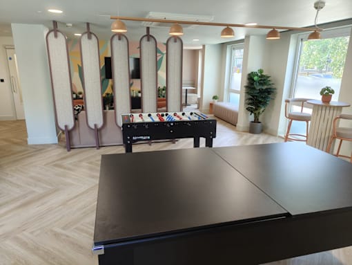A room with a long table and a DJ table in the middle.