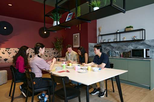 A group of people are sitting around a table eating food.