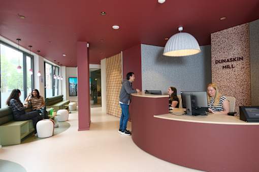 A reception area with people sitting and standing around.