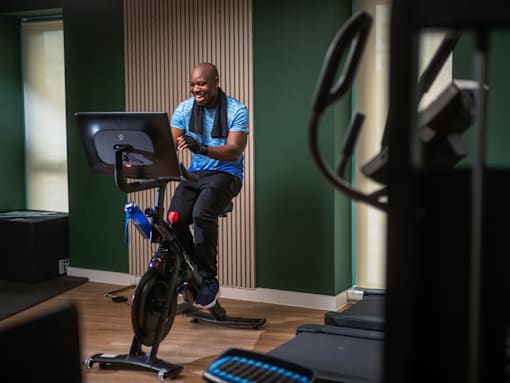 A man is exercising on a stationary bike in a room.