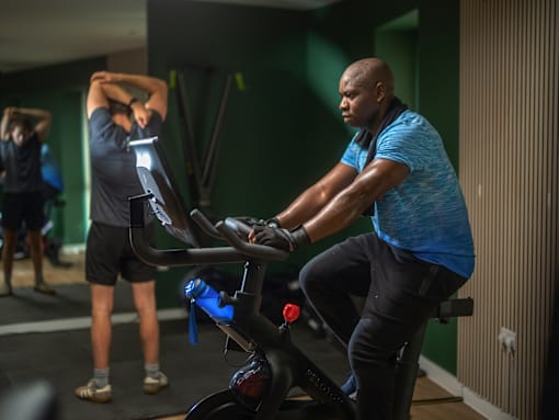 A man is working out on a stationary bike in a gym.