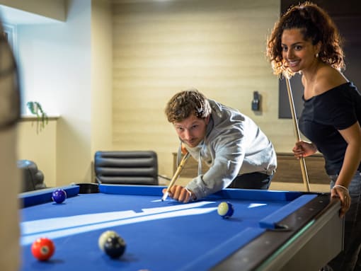 A man and a woman playing pool.