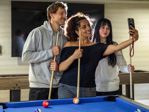 Three people taking a selfie at a pool table.