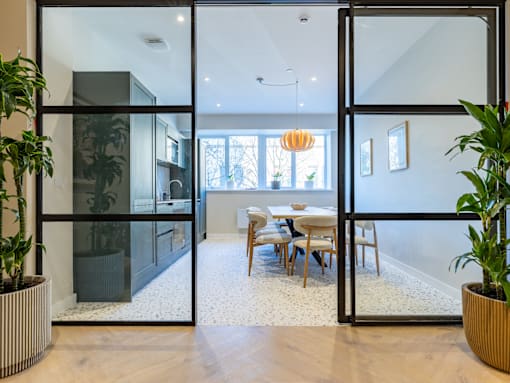 A modern dining room with a glass door entrance.