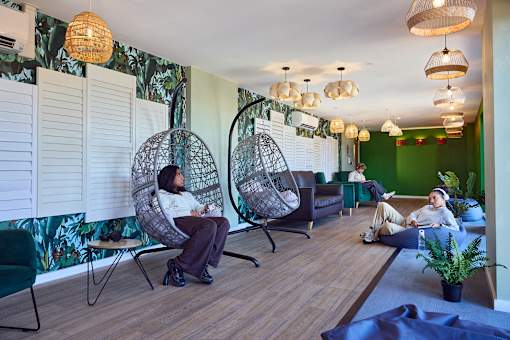 A woman is sitting in a chair in a room with green walls.