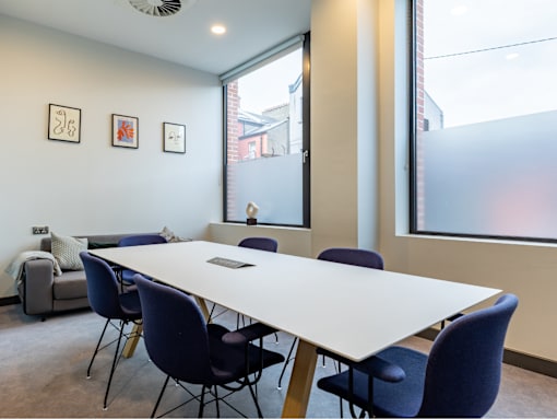 A conference room with a long table and chairs.