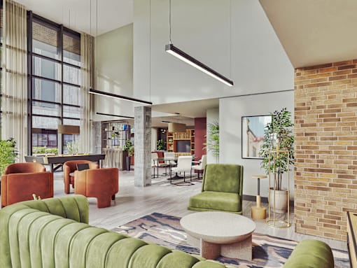 A modern living room with a green sofa and a brick wall.