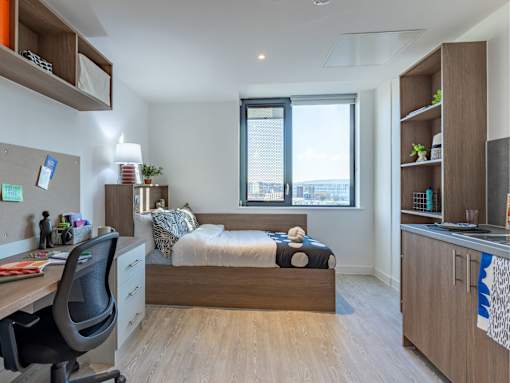 A bedroom with a bed, desk, and chair.