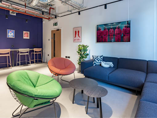 A room with a blue couch, a green chair, and a red chair.