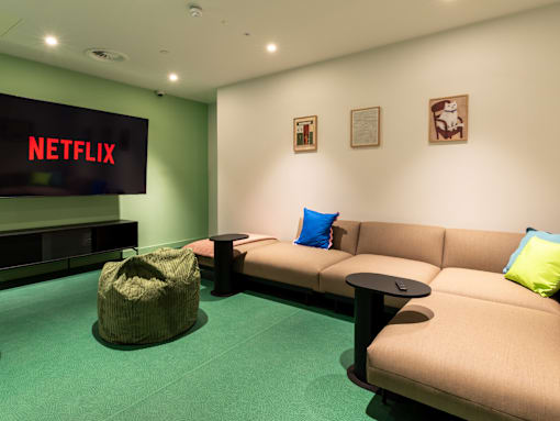 A Netflix sign is on a wall above a couch.