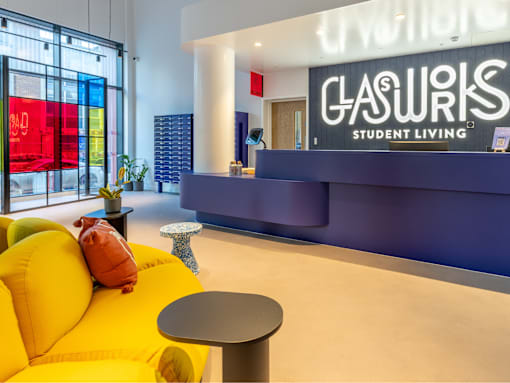 A bright yellow sofa sits in front of a sign that says Gasworks Student Living.