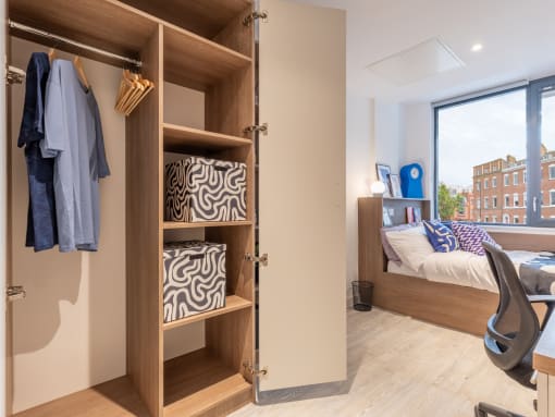 a closet in a bedroom with a bed and a window