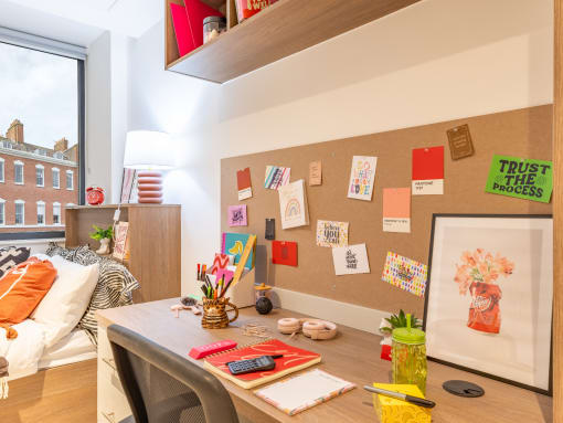 a home office with a desk and a bulletin board on the wall
