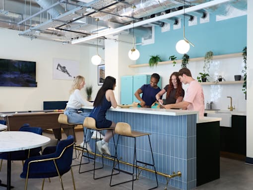 Four people are working at a blue counter.