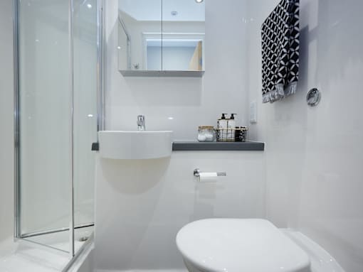 A white toilet in a modern bathroom with a glass shower door.