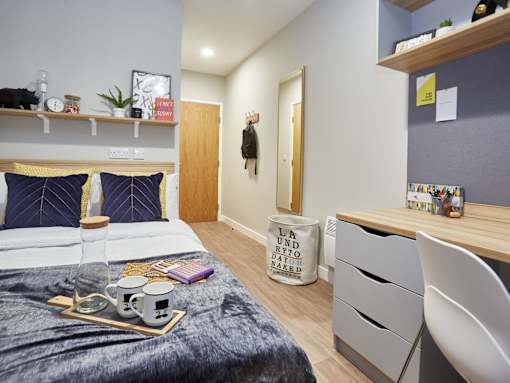A bedroom with a bed, desk, and chair.