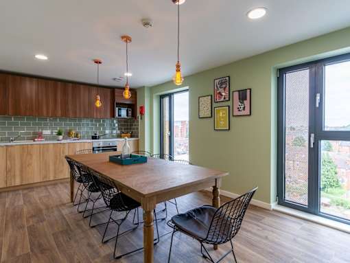 A kitchen with a table and chairs in front of a window.