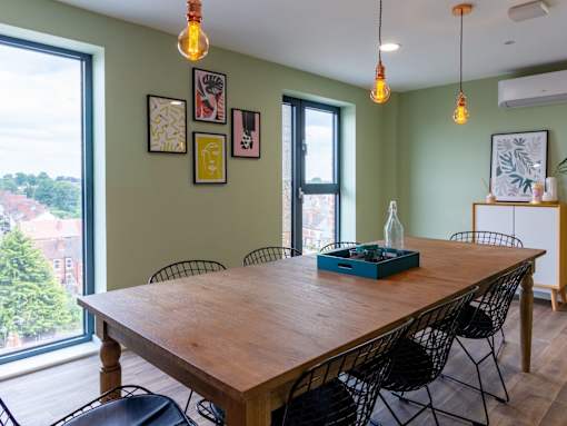 A dining room with a wooden table and chairs.