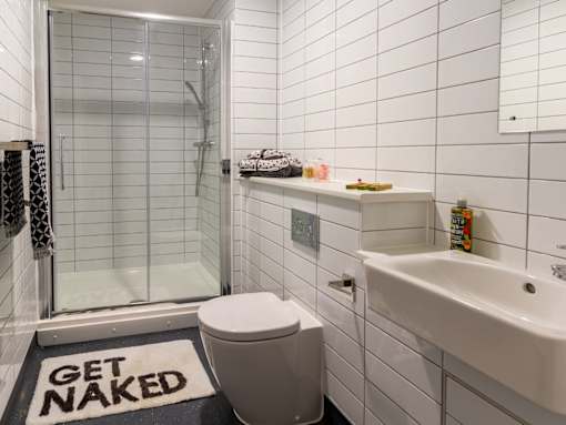 A bathroom with a toilet, sink, and shower.