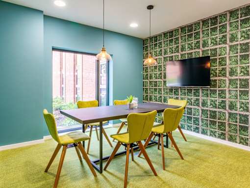 A dining room with a table and chairs.