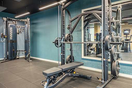 A gym with a blue wall and a variety of equipment.