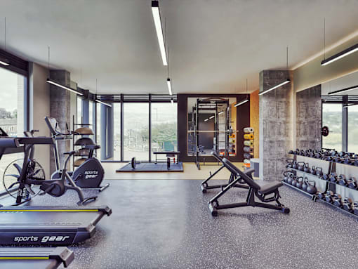 A gym with a variety of equipment including treadmills, weights, and exercise machines.