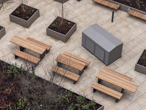A patio with benches and a planter.