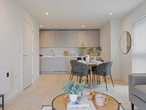 A modern kitchen with a dining table set for two.
