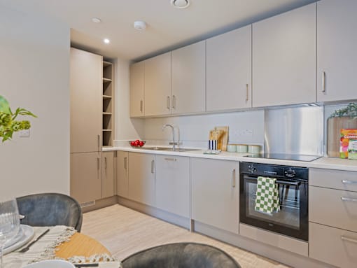 A modern kitchen with a table set for two.