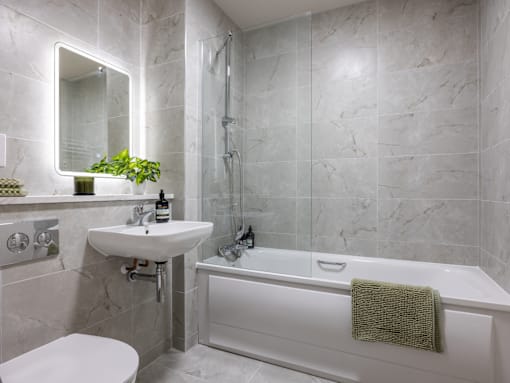 A white bathroom with a white tub and sink.