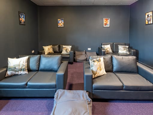 A row of grey couches with pillows on them.