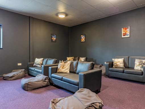 A living room with grey couches and pillows.