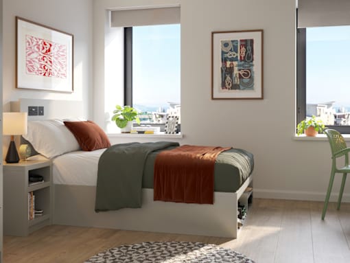 A bedroom with a large bed and two framed pictures on the wall.