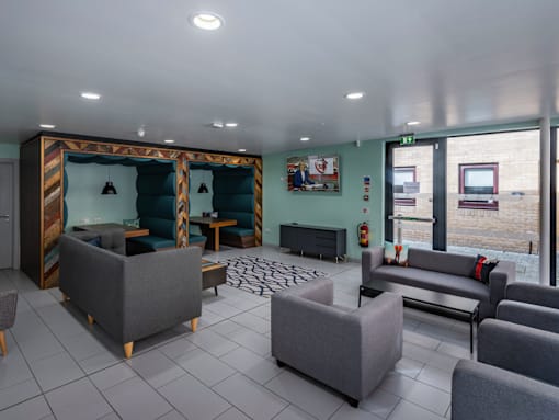 A living room with grey couches and a wooden cabinet.
