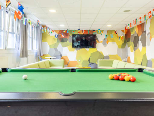 A pool table with a green cloth and a white ball on it.
