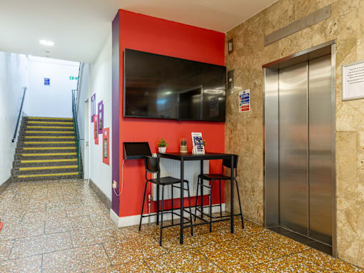 A room with a bar and a television on the wall.