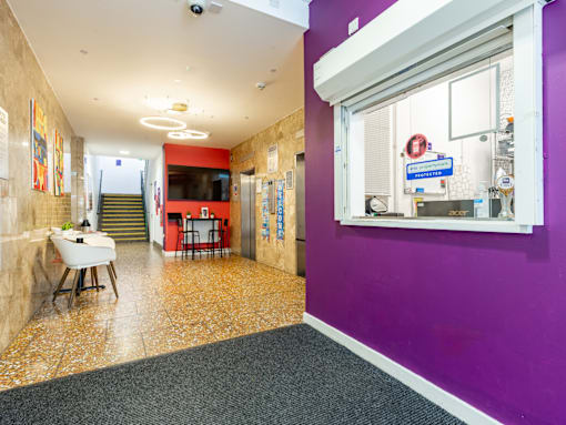 A hallway with a purple wall and a white table.