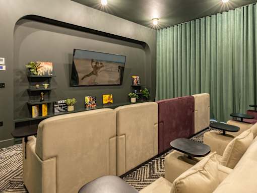 A living room with a large couch and a painting on the wall.
