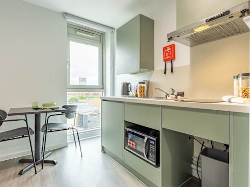 A kitchen with a green counter and a window.